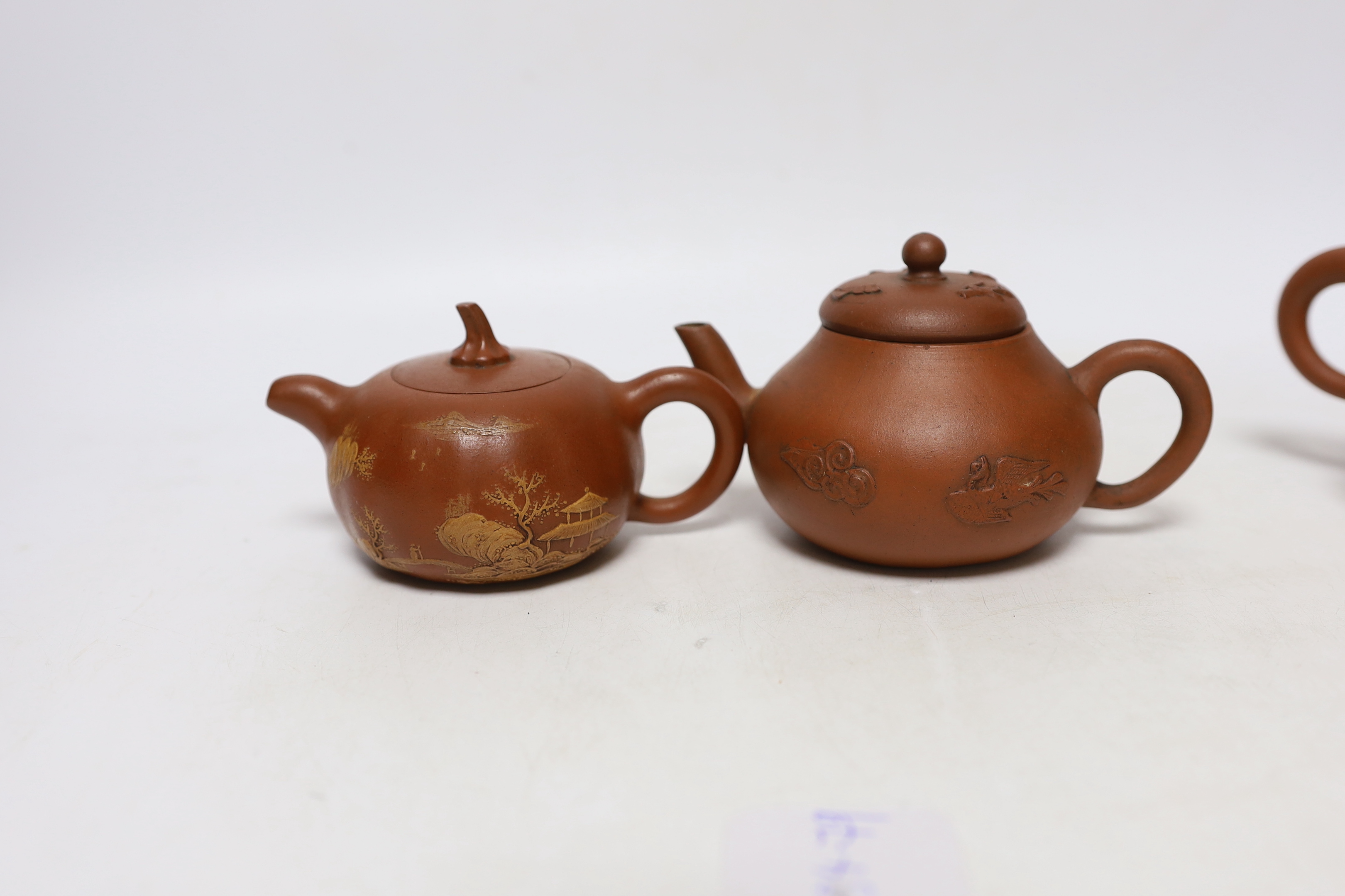 Four Chinese Yixing teapots, one slip decorated with a landscape, tallest 10.5cm